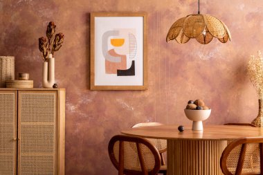 Stylish boho vintage dining room interior with poster mock up. Round table with rattan chair, commode and flowers. Brown wall and rattan lamp. Mock up poster. Template. 