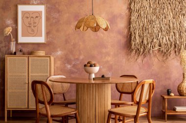 Stylish boho vintage dining room interior with poster mock up. Round table with rattan chair, commode and plants. Brown wall and rattan lamp. Mock up poster. Template. 