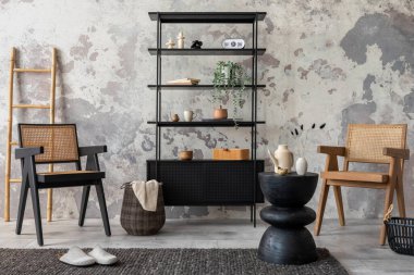 The stylish composition of wabi sabi interior with black rack, rattan armchair, carpet, coffee table and personal accesoories. Grey concrete wall. Home decor. Template. 