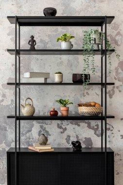 The stylish composition of wabi sabi interior with black rack with  personal accesoories. Grey concrete wall. Home decor. Template. 