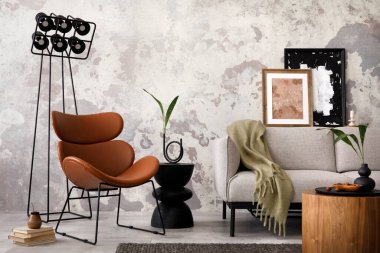 The stylish compostion at living room interior with design gray sofa, armchair, woooden coffee table, lamp and elegant personal accessories. Loft and industrial interior. Template. 