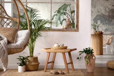 The stylish boho composition with changing swing, stool, window and plants. Beige carpet with brown slippers. White wall. Template.