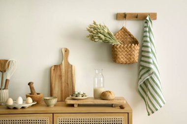 Interior design of kitchen space with rattan commode,  chair, herbs, vegetables, food and kitchen accessories in modern home decor. Template. 
