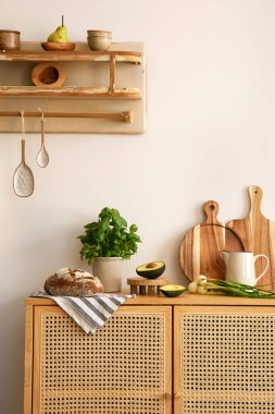 Interior design of kitchen space with rattan commode,  chair, herbs, vegetables, food and kitchen accessories in modern home decor.  Template. 