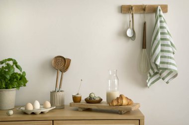 Interior design of kitchen space with rattan commode,  ladder, baking, food and kitchen accessories in modern home decor.  Template. 