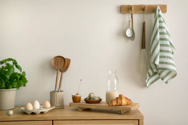 Interior design of kitchen space with rattan commode,  ladder, baking, food and kitchen accessories in modern home decor.  Template. 