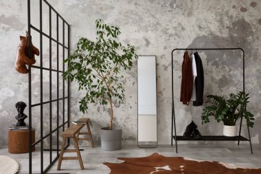 The stylish compostion at living room interior with concrete wall, hanger mirror, wooden bench and elegant personal accessories. Loft and industrial interior. Template. 