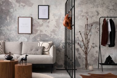 The stylish compostion at living room interior with design gray sofa, bench, coffee table, hanger, lamp and elegant personal accessories. Loft and industrial interior. Mock up poster. Template.