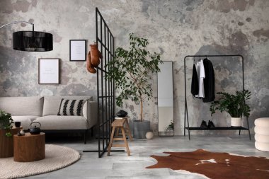 The stylish compostion at living room interior with design gray sofa, bench, coffee table, hanger, lamp and elegant personal accessories. Loft and industrial interior. Mock up poster. Template.