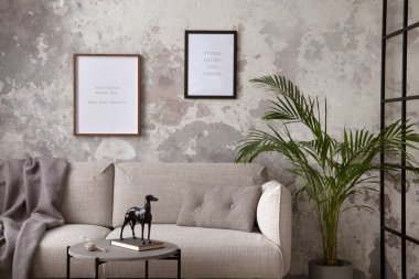 The stylish compostion at living room interior with design gray sofa, coffee table, plant, hanger, lamp and elegant personal accessories. Loft and industrial interior. Moc up poster. Template.