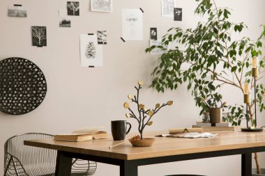 The stylish composition of cozy office interior with metal chair, wooden table, plants poster and personal accessories. Home decor. Template. 