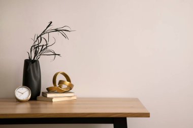 The stylish composition of cozy office interior with copy space, wooden table, vase with dried flowers and personal accessories. Home decor. Template. 