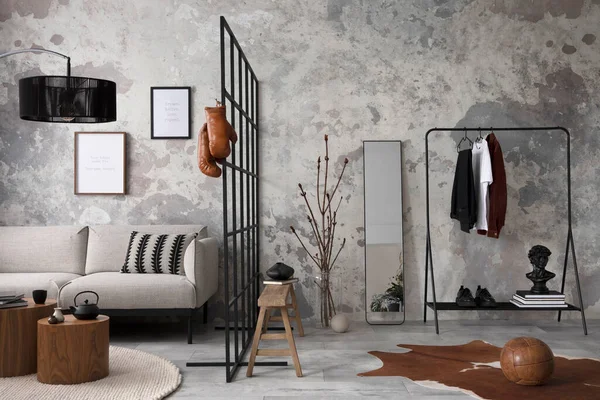 The stylish compostion at living room interior with design gray sofa, bench, coffee table, hanger, lamp and elegant personal accessories. Loft and industrial interior. Mock up poster. Template.