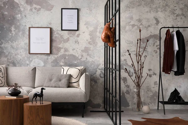 The stylish compostion at living room interior with design gray sofa, bench, coffee table, hanger, lamp and elegant personal accessories. Loft and industrial interior. Mock up poster. Template.