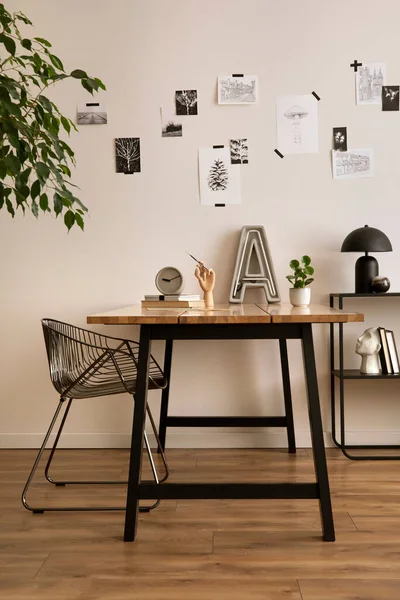 The stylish composition of cozy office interior with metal chair, wooden table, plants poster and personal accessories. Home decor. Template. 