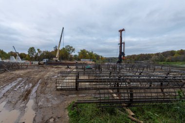 Nehir üzerinde bir köprü inşaatı. Metal tesisat güçlendirilmiş beton destekler için. İnşaat alanı, hazırlık çalışmaları.