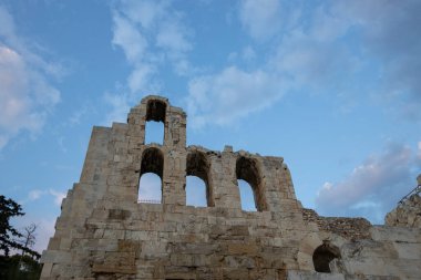 Antik Yunan mimarisinin kalıntılarının arka planında bulutlarla akşam gökyüzü