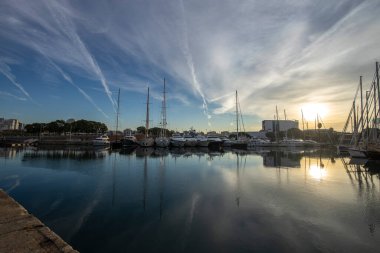 Barcelona, İspanya - 21 Aralık 2021: Barcelona, Port Vell 'de yelkenli ve marina Rambla de Mar. Güneşli bir sabahta yelkenli kullanmak. Geminin direkleri mavi gökyüzüne karşı. Sessiz ol