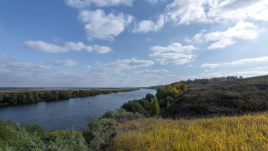 Nehir manzaralı sonbahar manzarası ve uçsuz bucaksız tarlalar. Nehir, tarla ve ağaçlarla panoramik manzara.