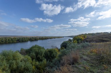 Nehir manzaralı sonbahar manzarası ve uçsuz bucaksız tarlalar. Nehir, tarla ve ağaçlarla panoramik manzara.