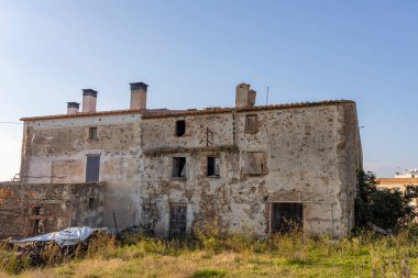 Eski terk edilmiş bir ev, mavi gökyüzüne karşı taş bina..
