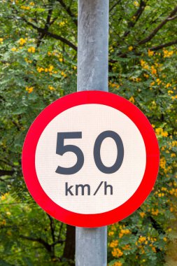 Trafik işaretleri maksimum hız, saatte 50 kilometre, arka planda yeşil bitki örtüsü
