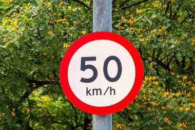 Trafik işaretleri maksimum hız, saatte 50 kilometre, arka planda yeşil bitki örtüsü
