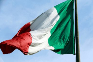 Italy flag fluttering in the wind with the sky in the background