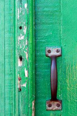 Closeup of lock and knob in closed green antique door  on colonial city of Santana do Parnaiba, Sao Paulo state, Brazil
