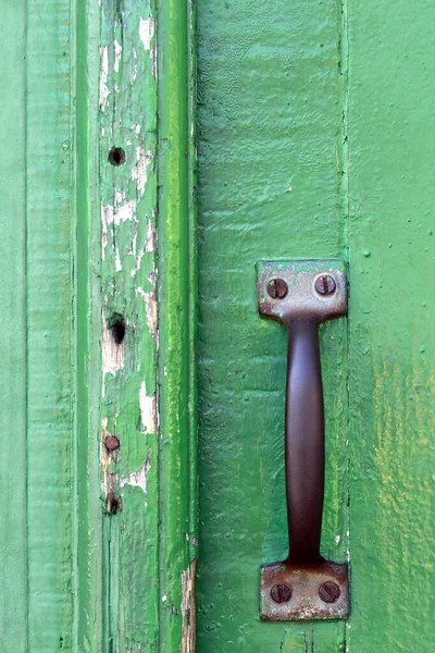 Closeup of lock and knob in closed green antique door  on colonial city of Santana do Parnaiba, Sao Paulo state, Brazil