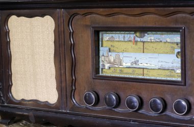 Düğmeleri olan ve ahşap gövdeyi çeviren klasik radyo önü