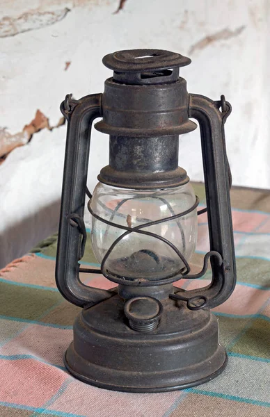 Old kerosene lamp over colored tablecloth
