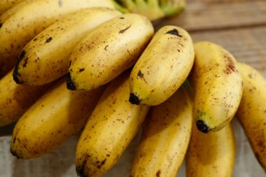 Kırsal ahşap masada altın rengi bir demet muz.