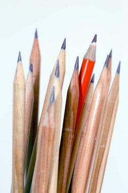 Odak ışık arka plan üzerinde doğal ahşap kalemler yolunda kırmızı kalem