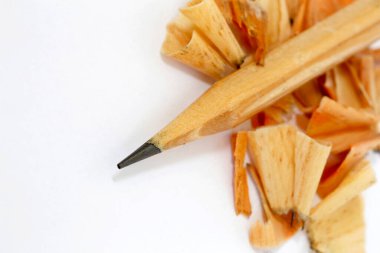 Kalem, tahta ve grafit talaşları ile keskinleştirilmiş, beyaz arka planda.