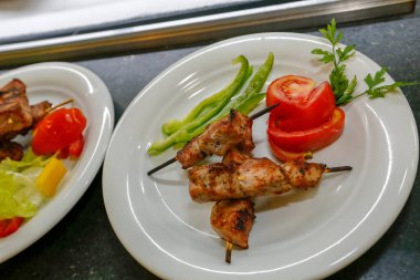 Kızarmış tavuk şişi ve salata ile tabak.