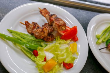 Kızarmış tavuk şişi ve salata ile tabak.