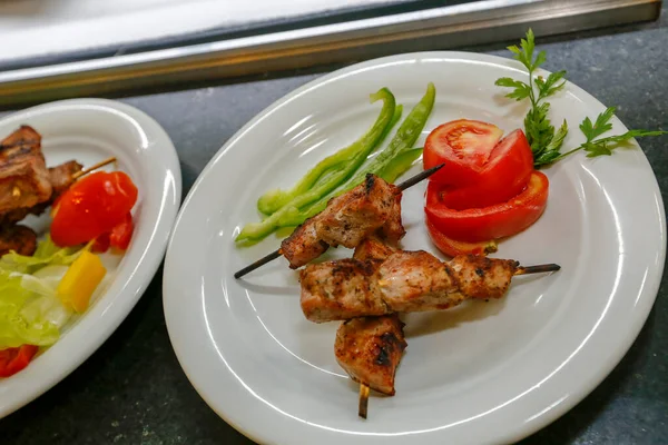 Kızarmış tavuk şişi ve salata ile tabak.