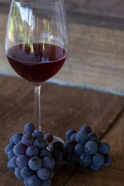 Bardak kırmızı şarap ve üzüm demet rustik ahşap tablo