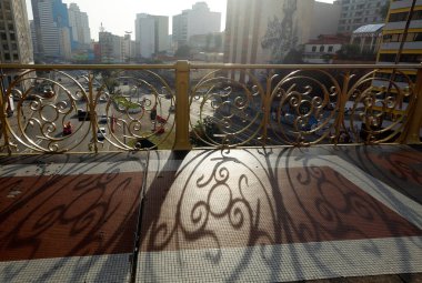 Viyadüğün yüzüncü yıl korkuluk detayı, arka ışıkta, kaldırımda gölgeler ve arka planda binalar. Viyadük Santa Efigenia, Sao Paulo city, Brezilya