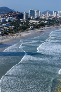 Şehir içinde belgili tanımlık geçmiş ile plaj isabet dalgalar. Guaruja, Sao Paulo devlet, Brezilya