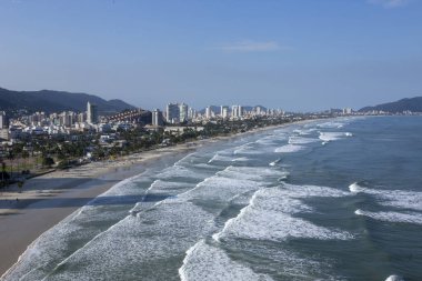 Şehir içinde belgili tanımlık geçmiş ile plaj isabet dalgalar. Guaruja, Sao Paulo devlet, Brezilya