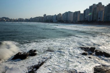 Şehir içinde belgili tanımlık geçmiş ile plaj isabet dalgalar. Guaruja, Sao Paulo devlet, Brezilya