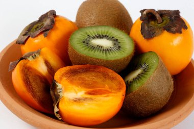 Beyaz arka planda kivriler, hurmalar ve kivilerle dolu bir hayat