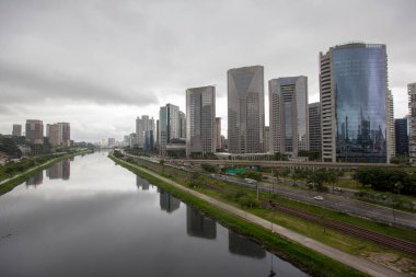 Marjinal Pinheiros binaların Pinheiros Nehri'nin sularında yağmurlu bir günde yansıtıyordu. Sao Paulo. Brezilya