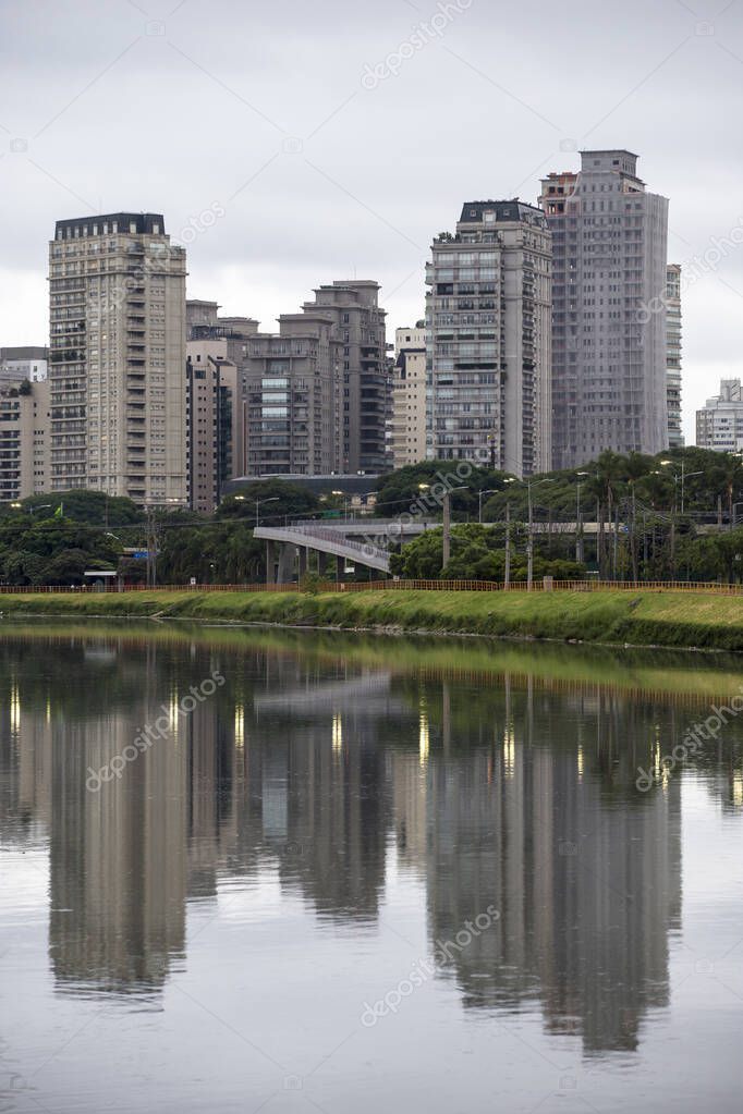 Buildings of Marginal Pinheiros reflected in the waters of the Pinheiros river, on a rainy day. Sao Paulo, Brazil