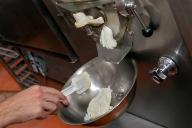 Pastanedeki makinede krema yapan bir hamur işi.