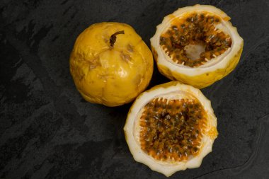 Çarkıfelek meyvesi, siyah taş masanın üzerinde, tek parça halinde.