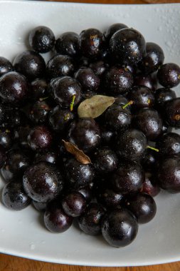Jaboticaba porsiyonlu, Brezilya üzümlü, beyaz tabakta, masa örtüsünde. Brezilya