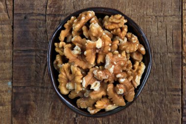 Kabuklu İran cevizi ve ahşap masa.